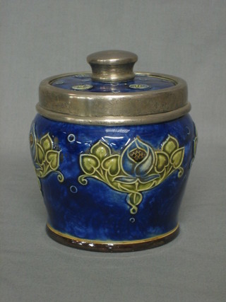 A circular Royal Doulton salt glazed tobacco jar with blue floral glazed decoration and silver rim, the base marked Royal Doulton and impressed BN 4"