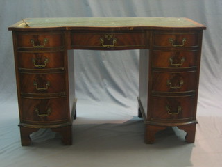 A 1950's Georgian style shaped mahogany desk with inset tooled leather writing surface above 1 long and 8 short drawers, raised on bracket feet 45"