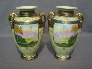 A pair of Japanese Noritake porcelain twin handled vases with landscape panelled decoration within blue and gilt borders 9"