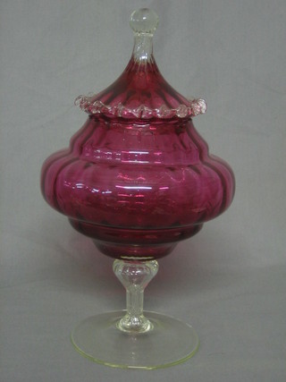 A cranberry glass jar and cover with clear glass base 13"