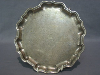 A circular silver salver with bracketed border, raised on 3 hoof feet, London 1911 10 ozs