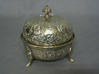 An Eastern embossed silver plated jar and cover, raised on 3 hoof feet