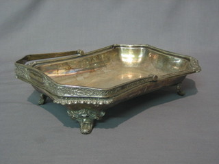 A rectangular silver plated cake basket with swing handle raised on panelled supports