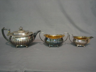 A George III silver 3 piece tea service of demi-reeded form, raised on 4 bun feet comprising teapot, twin handled sugar bowl and cream jug, London 1789, 42 ozs