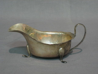 A Georgian style silver sauce boat with wavy cut border and C scroll handle, raised on 3 scroll feet, Sheffield 1937, 4 ozs