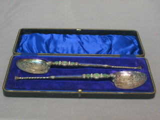 A pair of silver and enamelled anointing spoons, Birmingham 1909 and 1910, cased