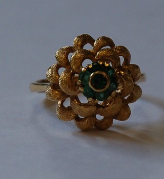 An 18ct gold dress ring set green stones