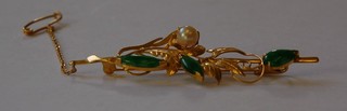 An Eastern "gold" brooch set green stones and pearls