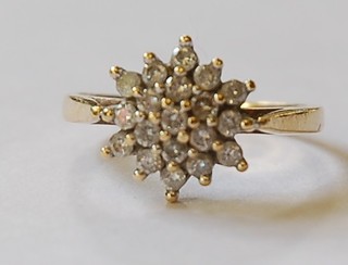 A lady's gold dress ring of cluster form set numerous diamonds
