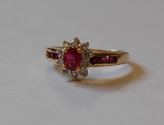 A lady's 9ct gold dress ring set an oval cut ruby supported by diamonds set numerous square cut rubies to the shoulder