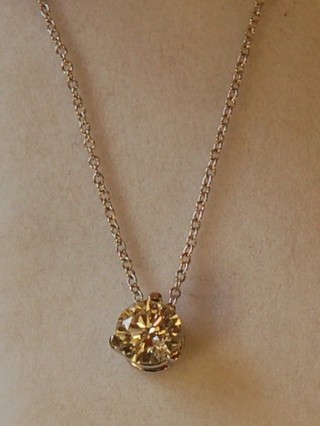 A solitaire diamond pendant hung on a fine chair approx 0.71ct
