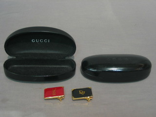 2 "Gucci" glass cases and 2 belt buckles marked Dior and Yves St Laurent