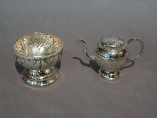 An Eastern embossed miniature silver teapot and a circular embossed sugar bowl