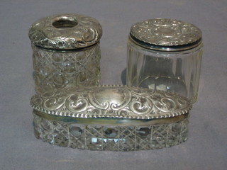 An oval cut glass dressing table jar with silver lid 4", a circular pin tray with silver lid 2" and a hair tidy with silver lid 2"