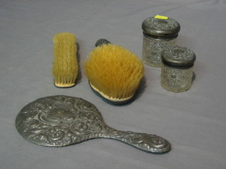 3 cut glass dressing table jars with silver lids and  a silver 3 piece backed dressing table set with handmirror, hair brush and clothes brush