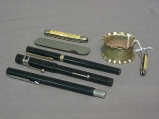 A silver plated napkin ring, 2 pocket knives, a folding comb, a black fountain pen The Scout, a Penquest fountain pen and a modern Parker fountain pen