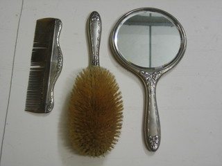 A 3 piece silver backed dressing table set comprising handmirror, hair brush and comb, Birmingham 1910