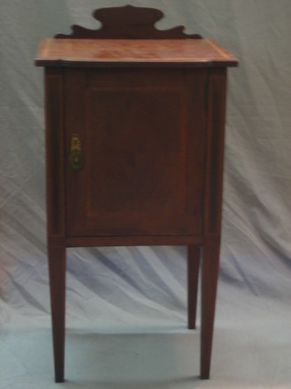 An Edwardian inlaid mahogany bedside cabinet enclosed by a panelled door, raised on square tapering supports 17"