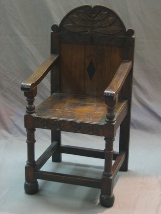 A 17th Century style oak open arm chair raised on turned and block supports