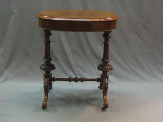 A Victorian oval figured walnut work table with hinged lid, raised on turned supports 24"