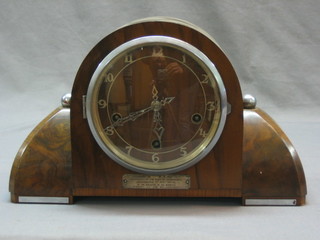 An Art Deco chiming mantel clock with Arabic numerals contained in a walnut case
