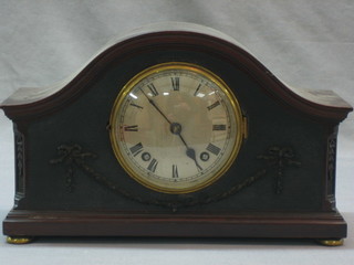 An Edwardian striking mantel clock with silvered dial and Roman numerals contained in a mahogany arch shaped case