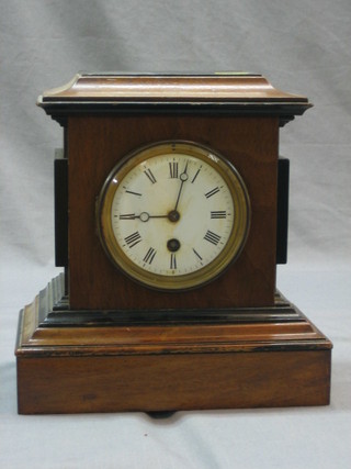 A Victorian mantel clock with enamelled dial and Arabic numerals contained in an ebonised case 