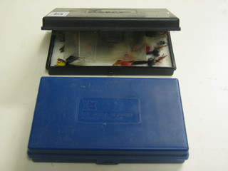 A Hardy's black plastic fly box containing various flies and a blue plastic fly box