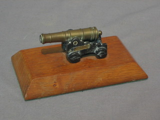 A 19th Century brass model canon with 2 1/2" brass barrel raised on an iron trunion