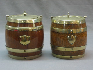 A pair of turned oak biscuit barrels with silver plated mounts