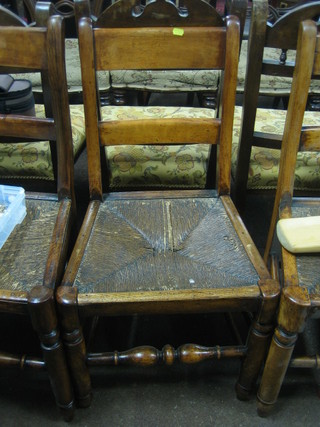 A set of 7 19th Century elm bar back dining chairs with woven rush seats, raised on turned supports