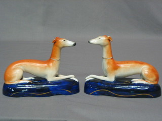 A pair of 19th Century Staffordshire pen rests in the form of seated grey hounds 7" (f)