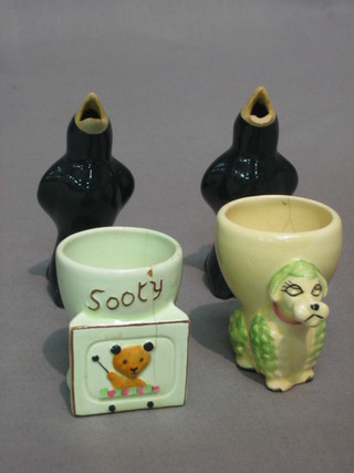 2 black glazed pottery pie stands in the form of crows (1f), an egg cup decorated Sooty (chipped) and an egg cup decorated a poodle