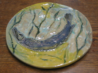 A Majolica style circular Studio Pottery plate decorated diving pike 10"
