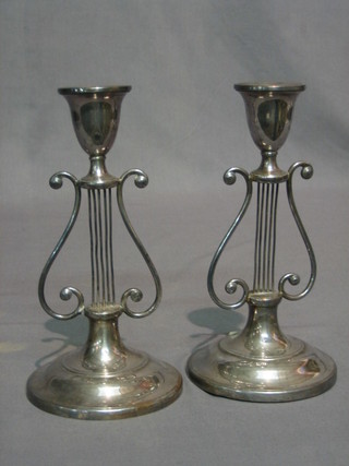 A pair of silver plated candlesticks with lyre decoration 8"