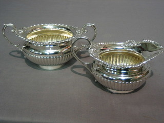 A Victorian, Georgian style silver cream jug with cast borders and demi-reeded body and a matching cream jug, London 1895 by the Goldsmiths and Silversmiths Co. 20 ozs