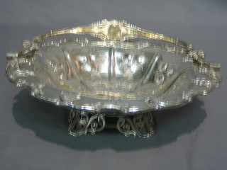 A Victorian embossed silver plated cake basket with swing handle, raised on pierced panel supports 11"