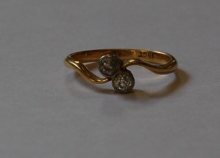 An 18ct gold cross-over dress ring set 2 diamonds