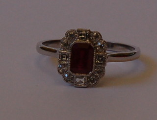 A lady's 18ct gold dress ring set a rectangular cut ruby surrounded by numerous diamonds