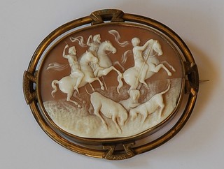 A shell carved cameo brooch depicting a hunting scene contained in a pinch beck mount 2"