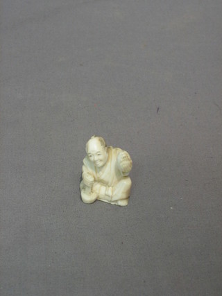 A carved ivory figure of a seated boy 2"
