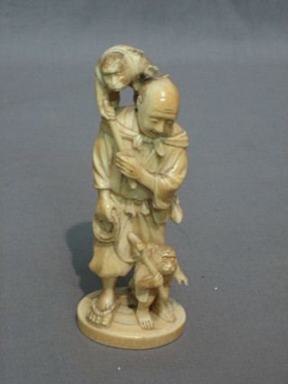 A carved ivory figure of a standing man with 2 monkeys 5"