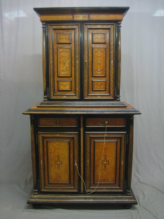 A handsome 20th Century Florentine ebonised and figured walnut cabinet on cabinet, the upper section with moulded cornice above a cupboard enclosed by panelled doors flanked by a pair of columns, the base fitted 2 short drawers above a cupboard enclosed by panelled doors and flanked by columns to the side 39"
