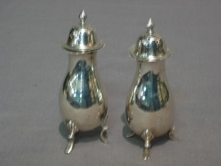 A pair of silver pepperettes raised on  circular spreading feet, marks rubbed, 2 ozs