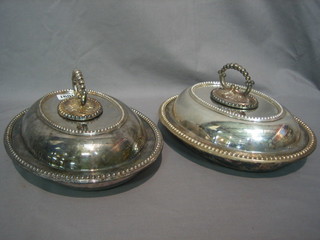A pair of silver plated oval entree dishes and covers with bead work borders