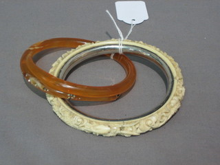 A carved ivory bangle and a costume jewellery bangle