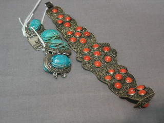 A silver and turquoise bracelet decorated scarabs and 1 other bracelet