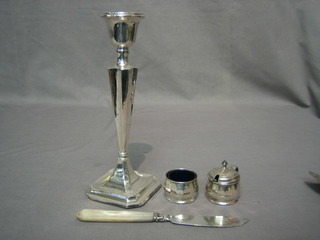 A silver candlestick 9", a silver mustard and salt pot and a Victorian silver bladed butter knife with mother of pearl handle