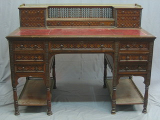 A Victorian carved mahogany Colonial desk with raised super structure to the back with brass three-quarter gallery, fitted 1 long and 2 short drawers flanked by 6 short drawers, having an inset red leather writing surface, the base fitted 1 long drawer above 6 short drawers the base fitted an undertier with brass gallery, raised on turned supports 50"