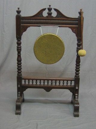 A late Victorian dinner gong contained within a carved walnut frame complete with beater 35"